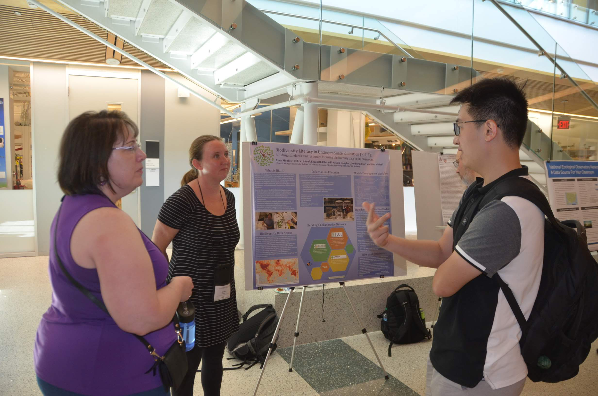 Debra Linton and Molly Phillips speaking with a student at the poster session